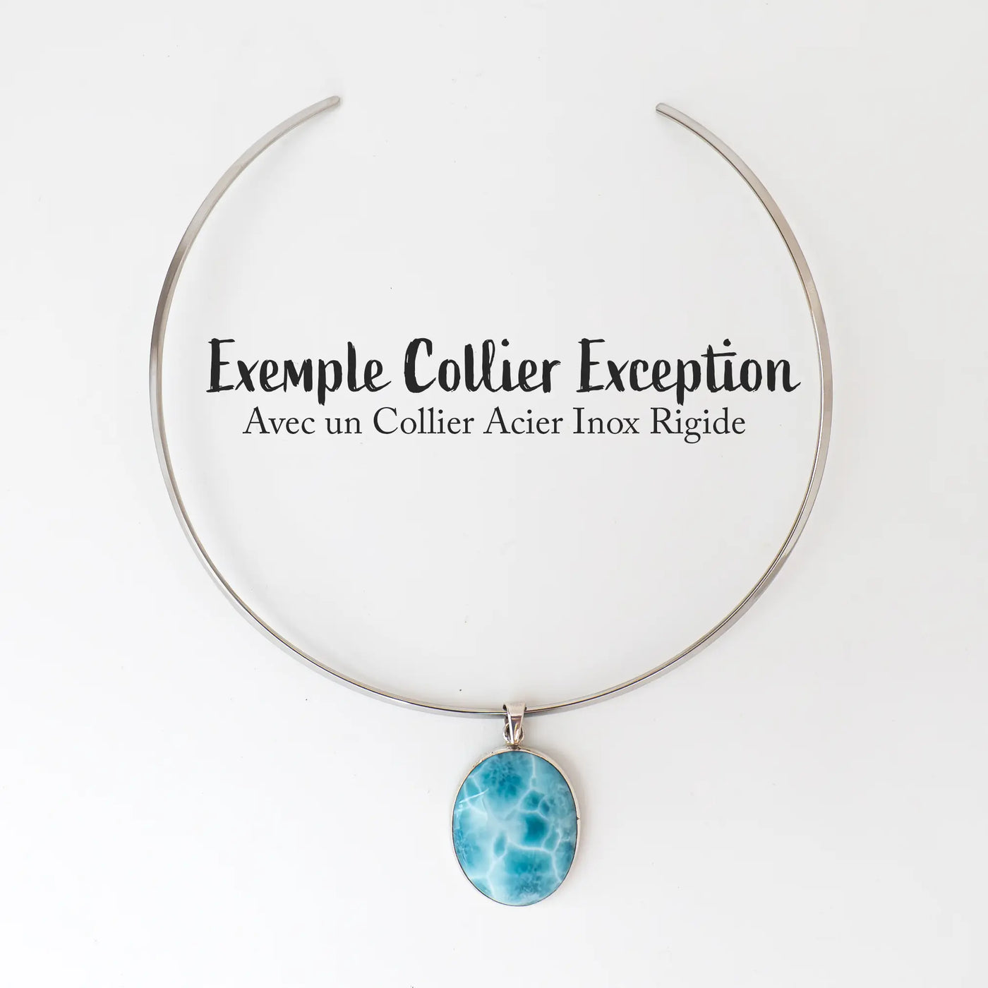 Collier en acier inoxydable avec son pendentif en Larimar de qualité exceptionnelle, posé à plat sur fond blanc. Le pendentif en larimar est d'un bleu aux multiples nuances avec des veines de blanc.