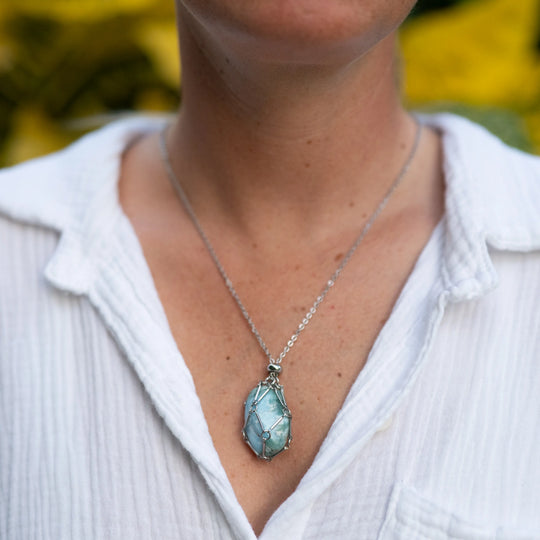 Pierre polie de Larimar de République Dominicaine contenue dans une cage ouvrable en acier inoxydable 316L. Collier avec sa pierre naturelle de Larimar.