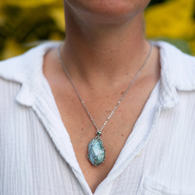 Pierre polie de Larimar de République Dominicaine contenue dans une cage ouvrable en acier inoxydable 316L. Collier avec sa pierre naturelle de Larimar.