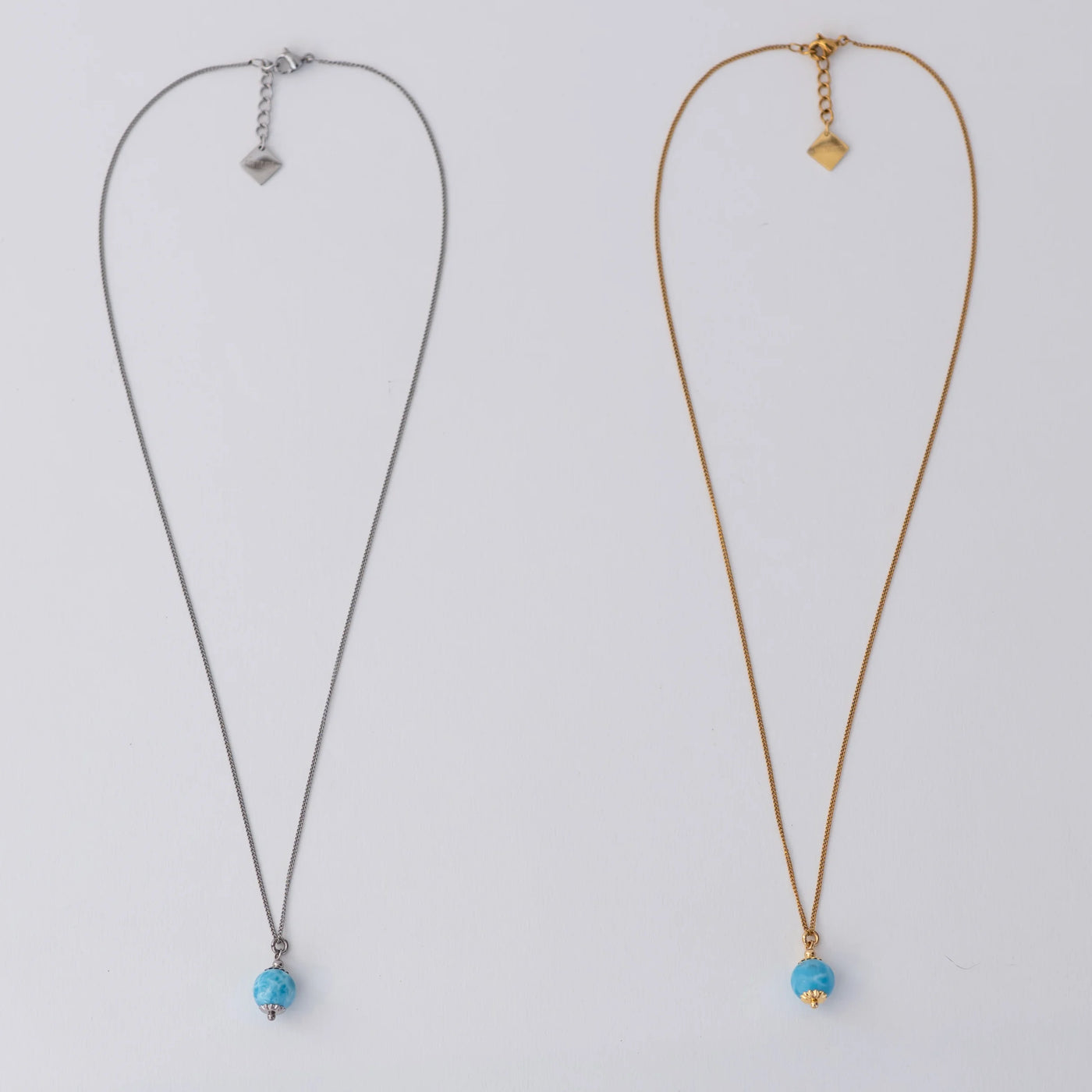 Deux colliers avec une perle de larimar comme pendant. Bijoux en acier inoxydable 316L argenté et doré.