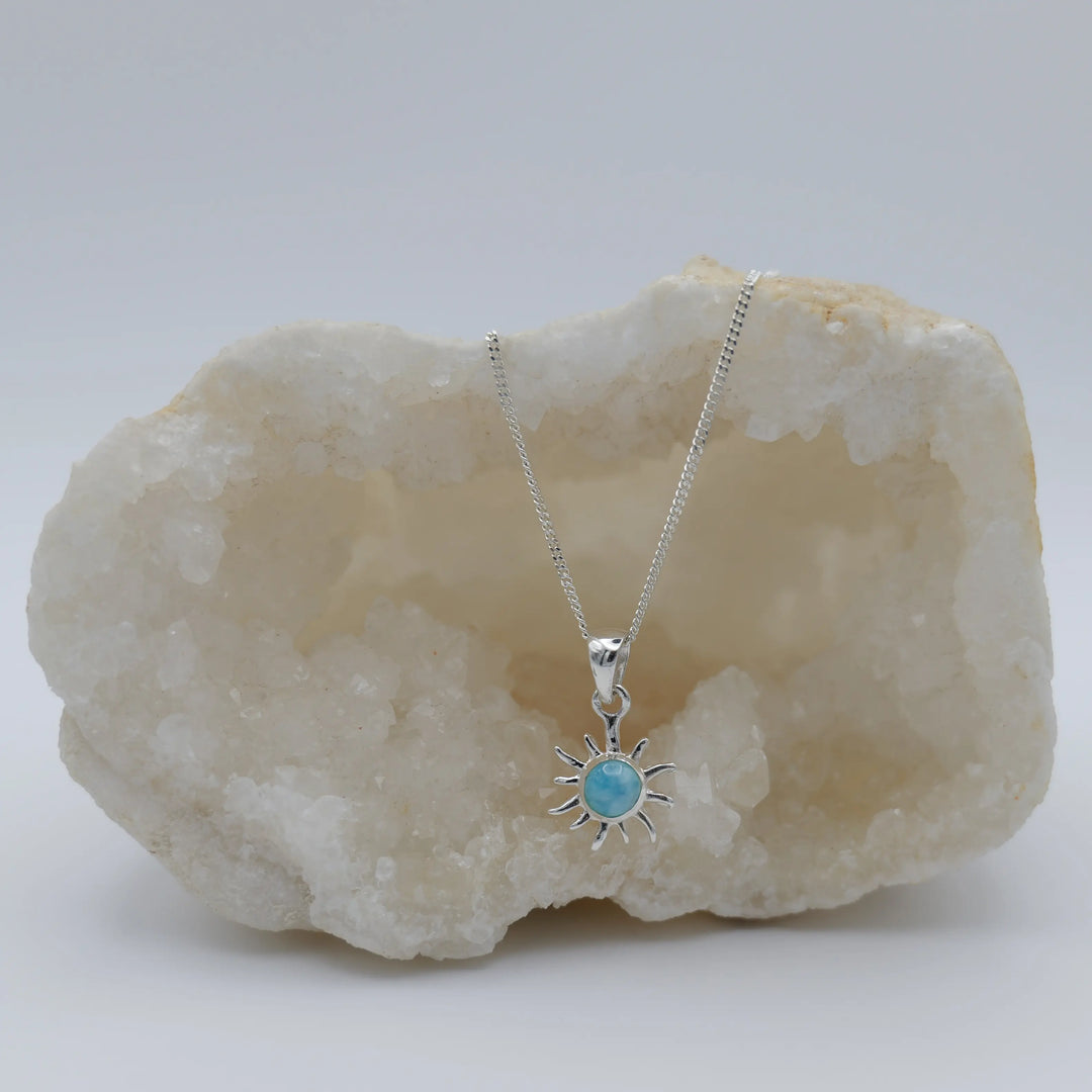 Petit soleil avec une pierre de Larimar ronde en son centre, monté sur une chaîne en argent 925.
