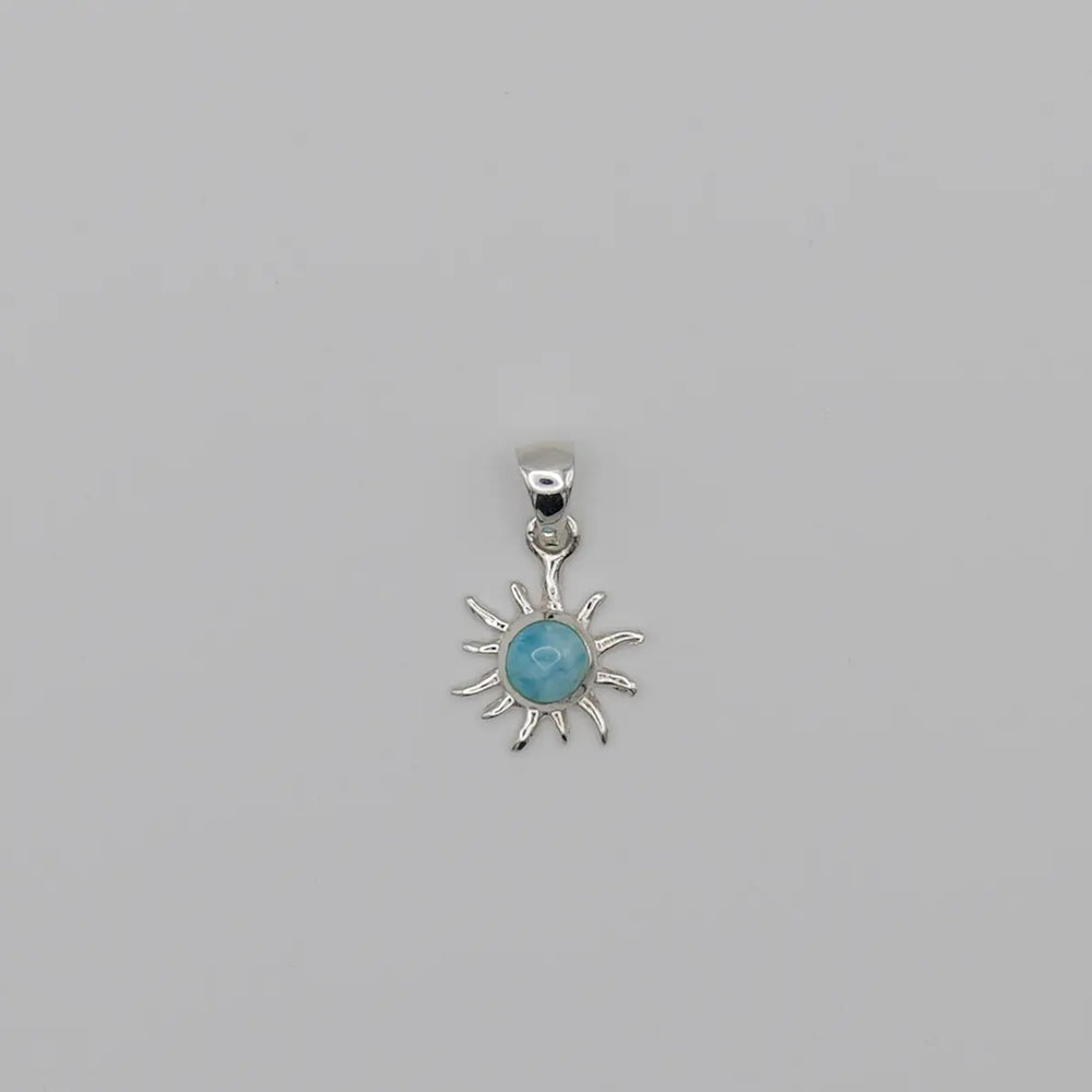 Superbe pendentif en forme de soleil. Bijou fait à la main avec une pierre naturelle bleue, du Larimar, sertie au centre du soleil.