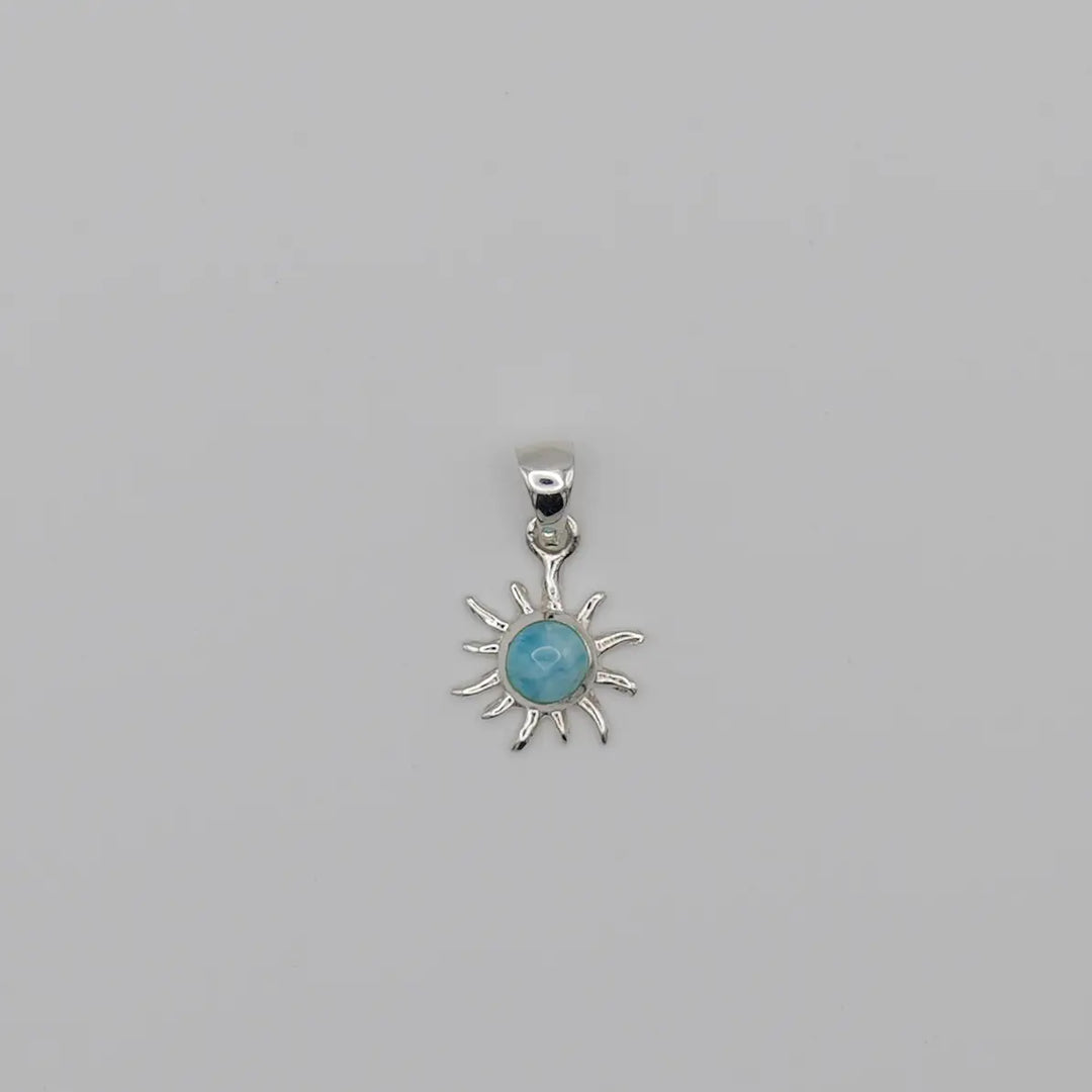 Superbe pendentif en forme de soleil. Bijou fait à la main avec une pierre naturelle bleue, du Larimar, sertie au centre du soleil.