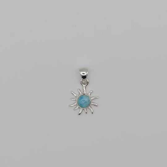 Superbe pendentif en forme de soleil. Bijou fait à la main avec une pierre naturelle bleue, du Larimar, sertie au centre du soleil.