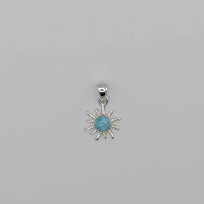 Superbe pendentif en forme de soleil. Bijou fait à la main avec une pierre naturelle bleue, du Larimar, sertie au centre du soleil.