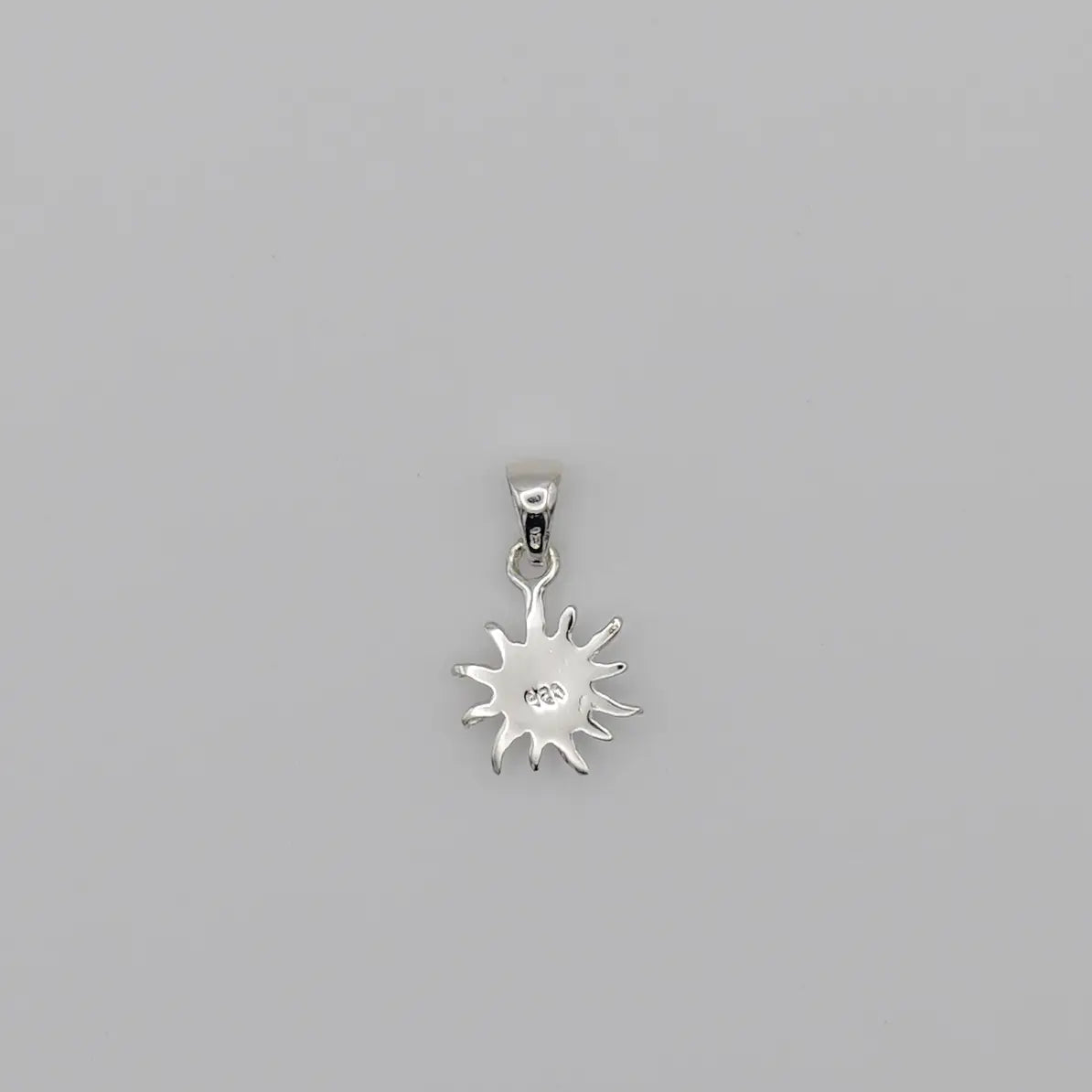 Pendentif en forme de soleil vue sur sa face verso avec un marquage 925. Bijou artisanal fait en République Dominicaine.