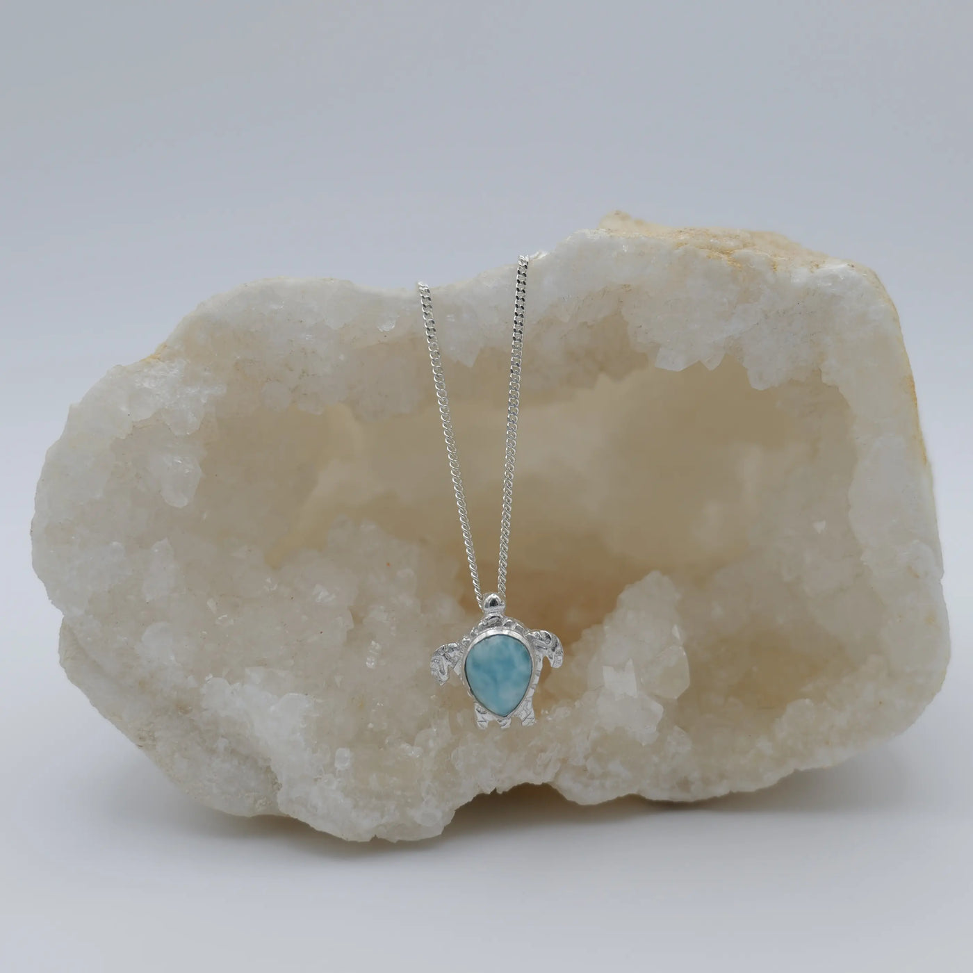 Pendentif en forme de tortue et sa chaîne, le tout en argent 925. Pierre de Larimar bleue sertie au centre du collier.