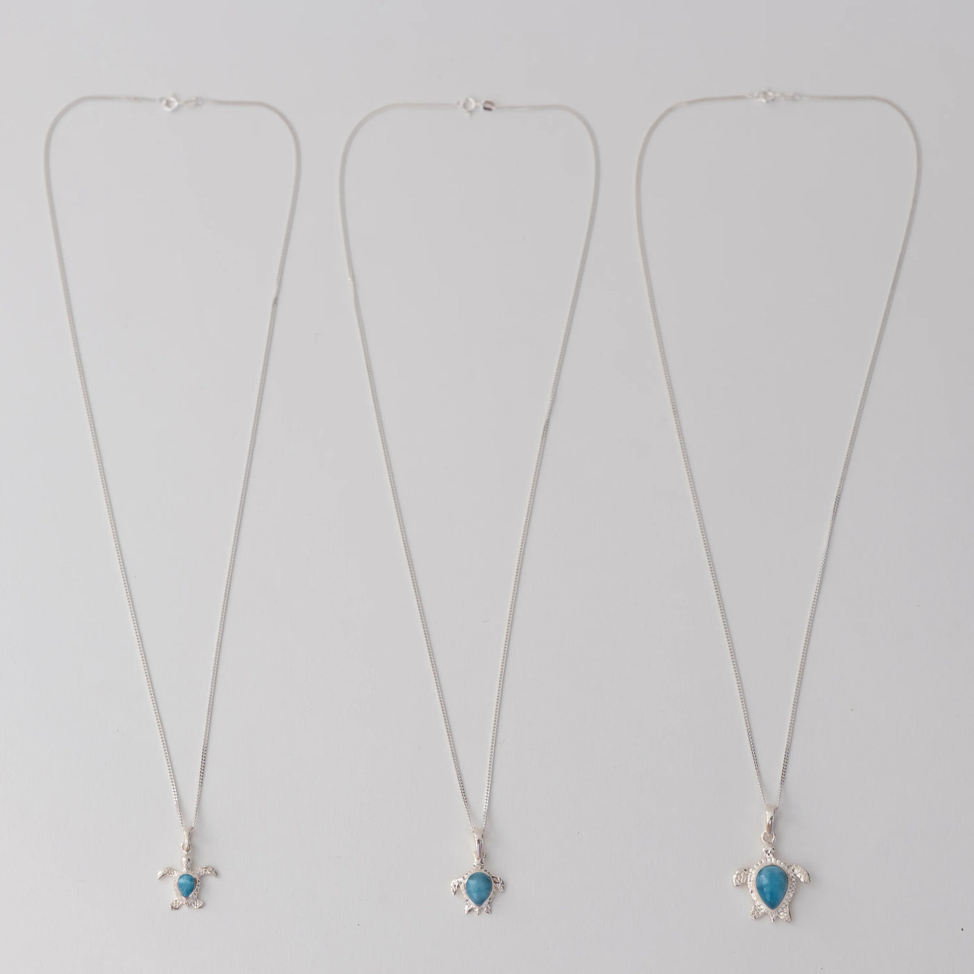Trois chaines en argent 925 avec chacune une tortue en argent 925 et larimar, de tailles différentes.