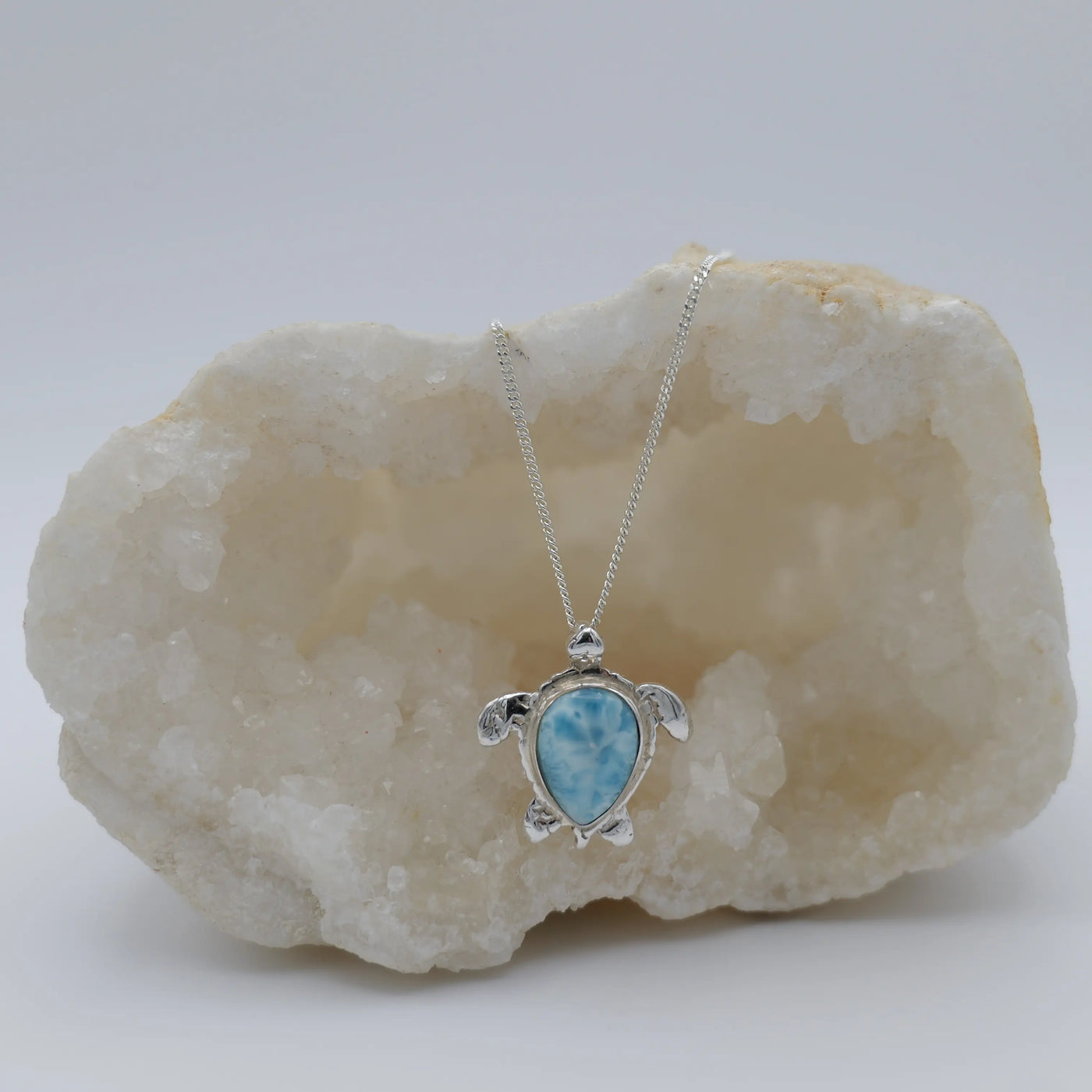 Pierre de Larimar ovale sertie au centre d'une tortue en argent 925, le tout forme un collier original, un bijou artisanal.
