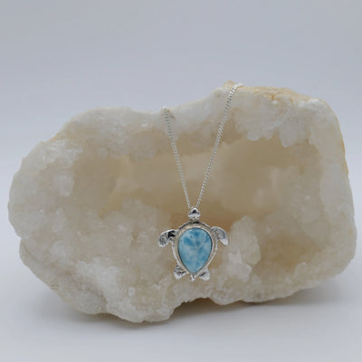 Pierre de Larimar ovale sertie au centre d'une tortue en argent 925, le tout forme un collier original, un bijou artisanal.