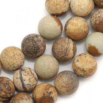 Plusieurs perles de Jaspe paysage sont photographiées de très prés. Ces perles ont une couleur marron faisant penser à du bois ou à de la roche désertique.