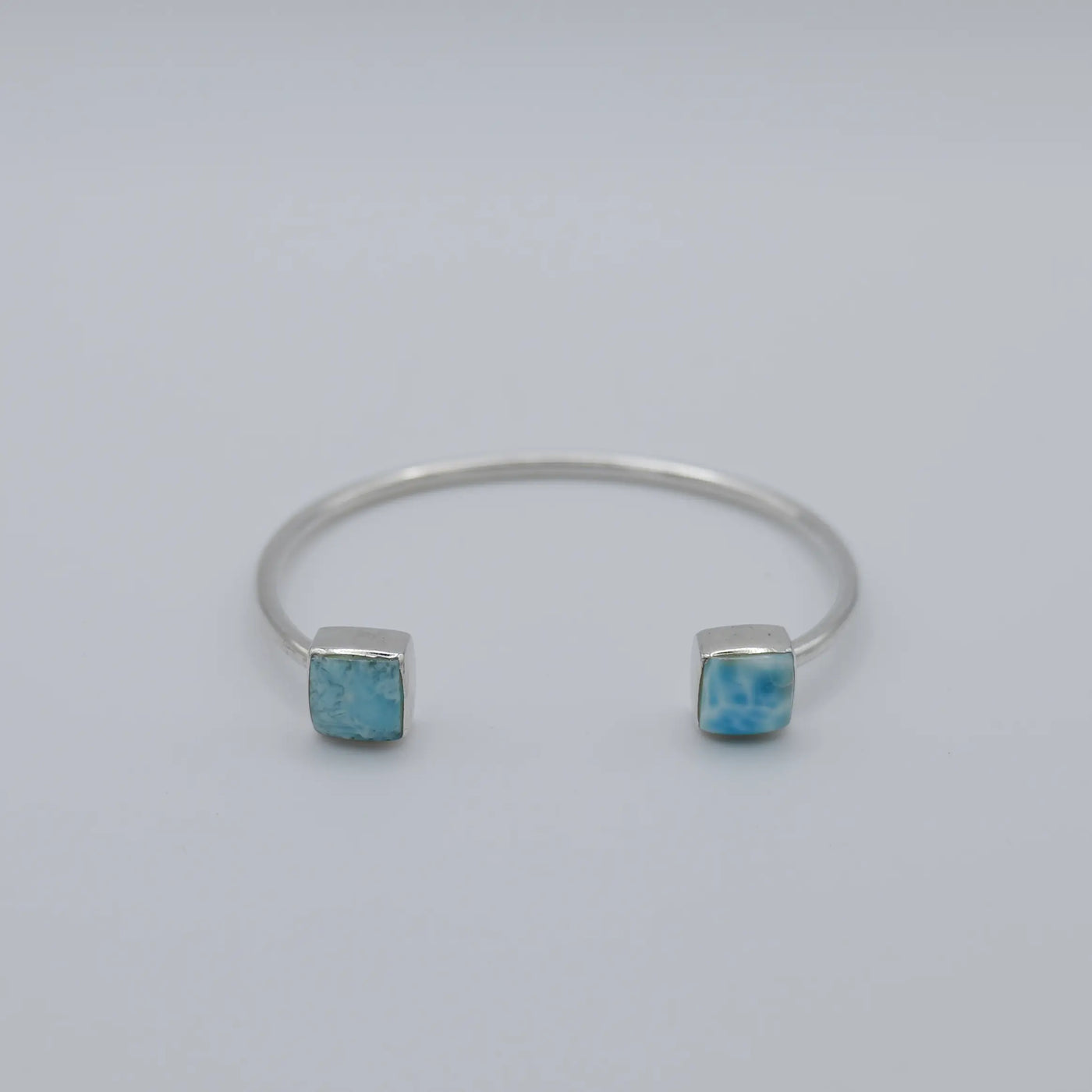 Deux cabochons carrés en pierre naturelle de Larimar sertis au extrémité d'un jonc en argent 925.