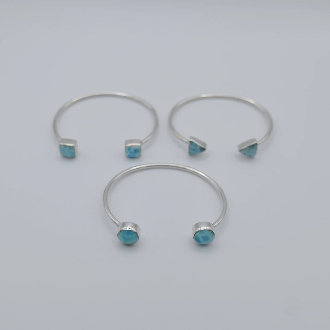 Trois joncs en argent 925 avec du Larimar de couleur bleu de différentes formes sur chaque extrémités des joncs.