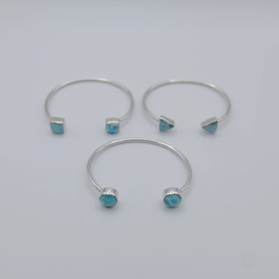 Trois joncs en argent 925 avec du Larimar de couleur bleu de différentes formes sur chaque extrémités des joncs.
