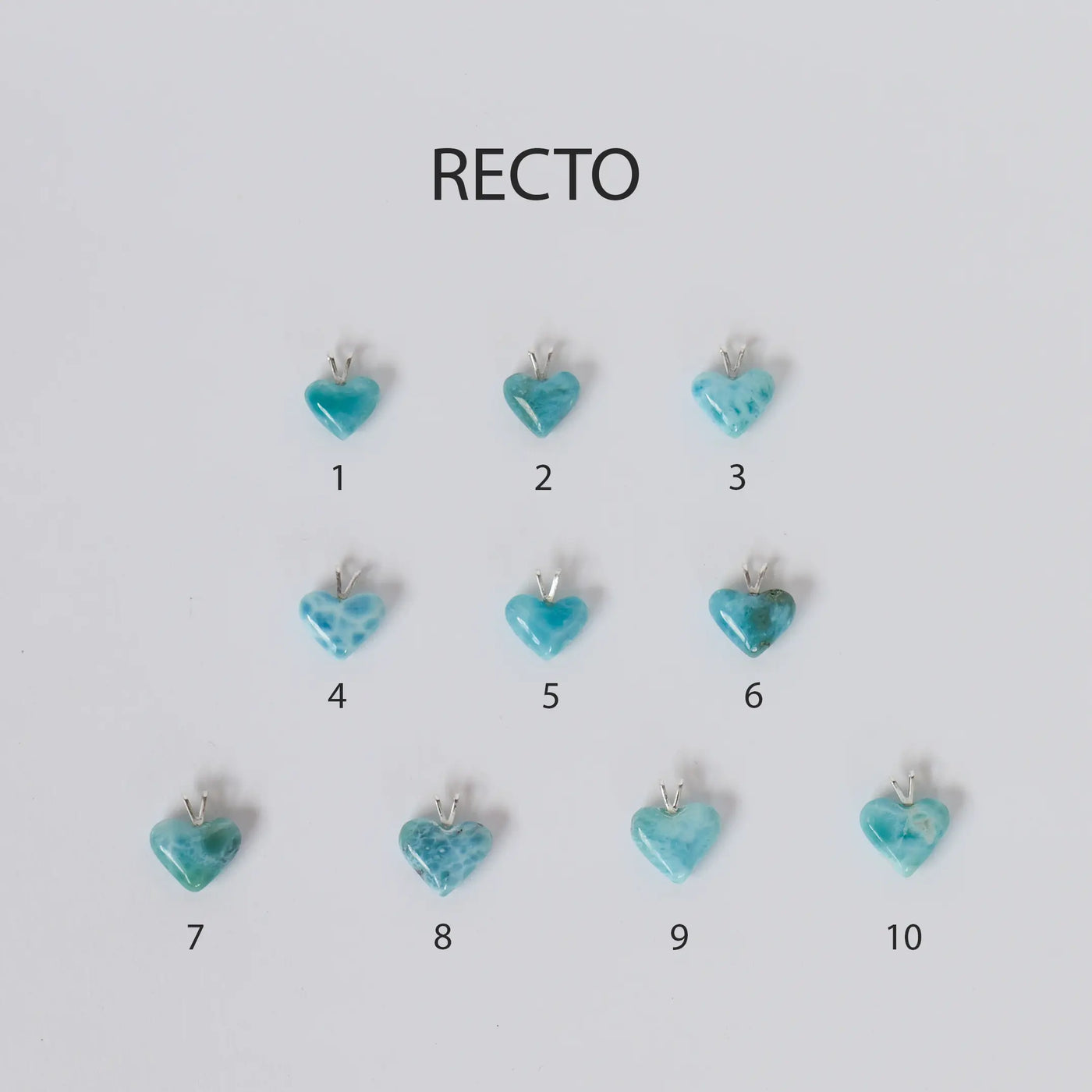 Dix pendentifs en forme de cœurs face recto sont pris en photo du dessus. Ces cœurs sont fait en Larimar venant de République Dominicaine. Chaque bijou est d'une couleur bleu différente rendant chaque cœur unique et original.