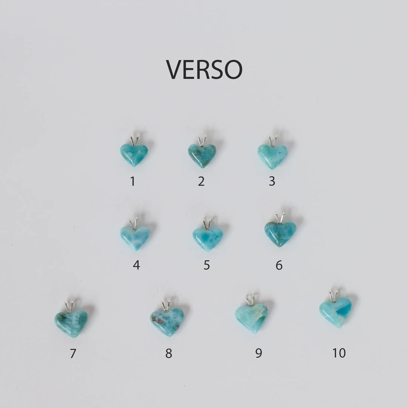 Des cœurs en Larimar avec une attache en argent 925 sont exposés face verso sur un fond blanc. Ces cœurs, au nombre de dix, semblent être des pendentifs pouvant être montés sur un fil transparent ou une chaîne en argent 925.