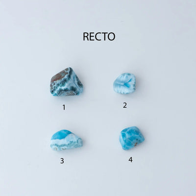 Photo de quatre pierres roulées faite en Larimar, une pierre d'énergie de République Dominicaine. Chaque pierre est différente, avec différentes couleur de bleu, de blanc et de vert. La pierre numéro une et la numéro quatre ont des incrustations de roche de couleur marron.