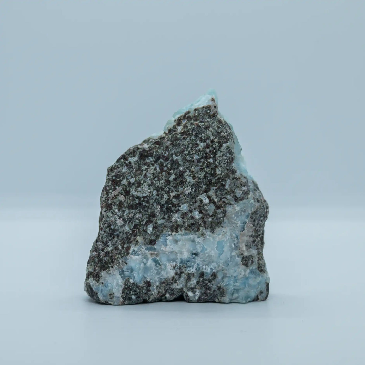 Vue de la face verso d'un bloc de roche sur lequel on observe plusieurs veines de Larimar. Pierre naturelle pour collectionneur venant de République Dominicaine.