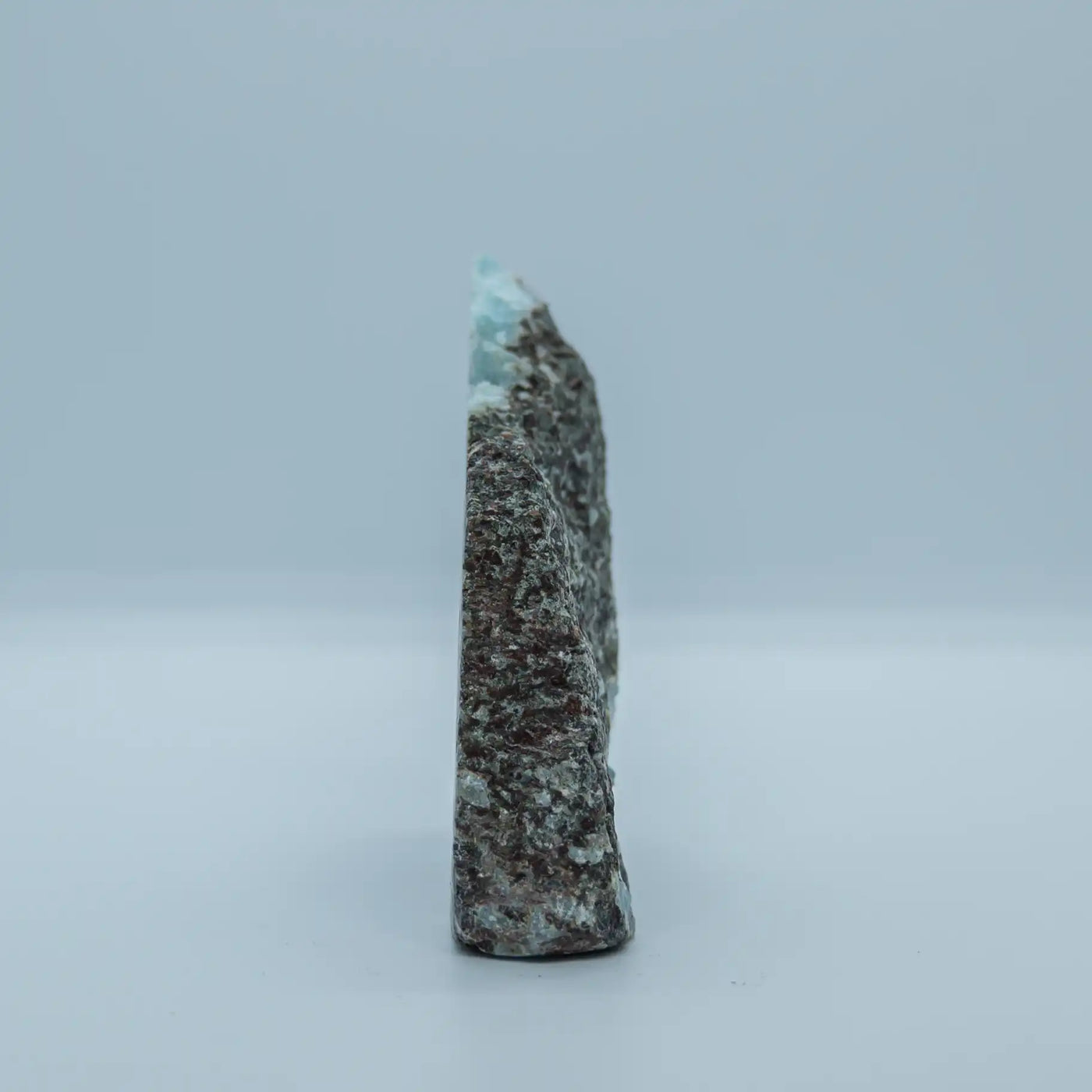 Face verso d'un morceau de roche contenant de la pierre naturelle de Larimar extrait en République Dominicaine. Pierre brut avec une seul face polie.