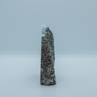 Face verso d'un morceau de roche contenant de la pierre naturelle de Larimar extrait en République Dominicaine. Pierre brut avec une seul face polie.