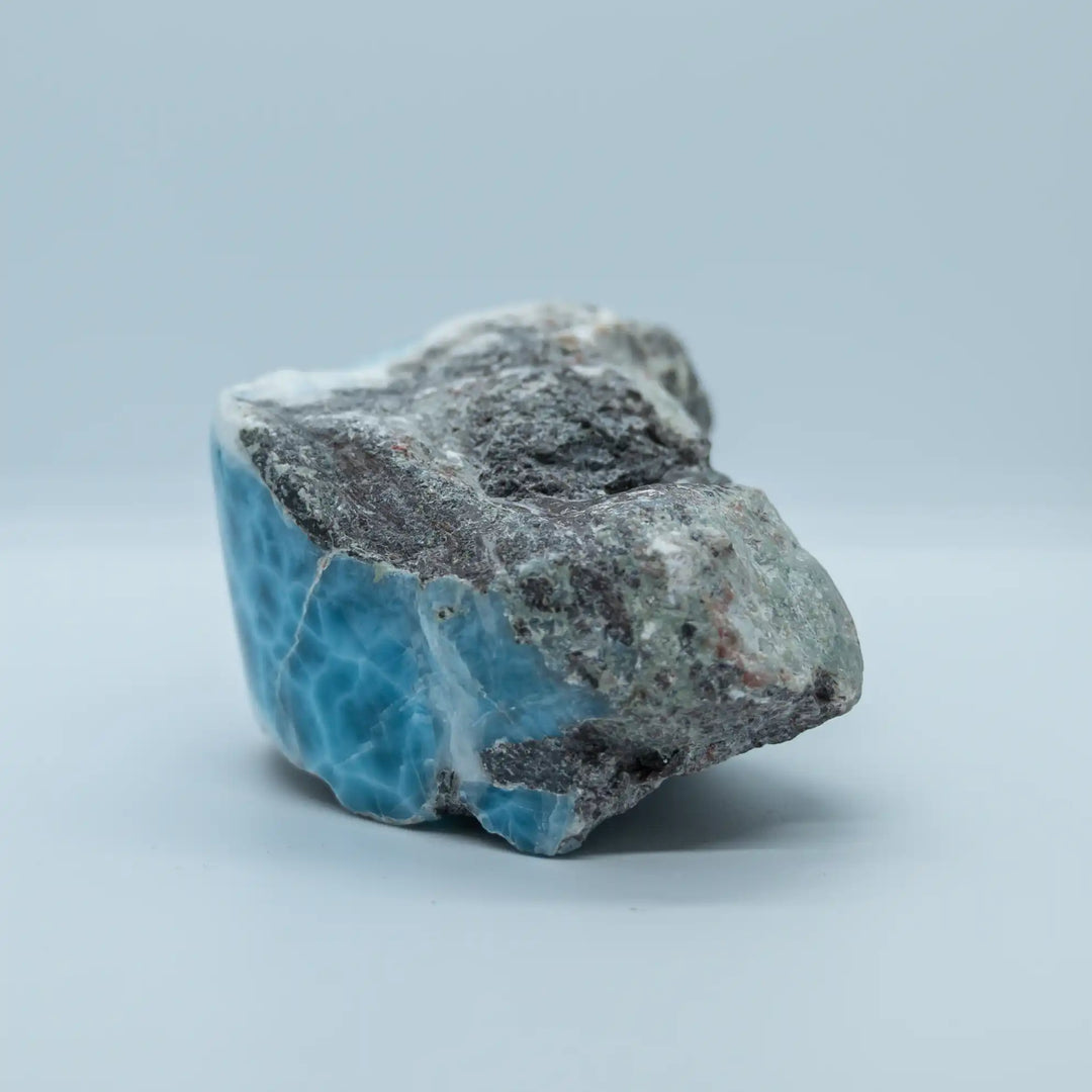Pierre naturelle de Larimar sous forme de bloc venant de la mine en République Dominicaine. Cette vue de profil laisse apparaître une partie bien bleue de Larimar et une partie rocheuse. Pierre naturelle idéale pour les collectionneur.