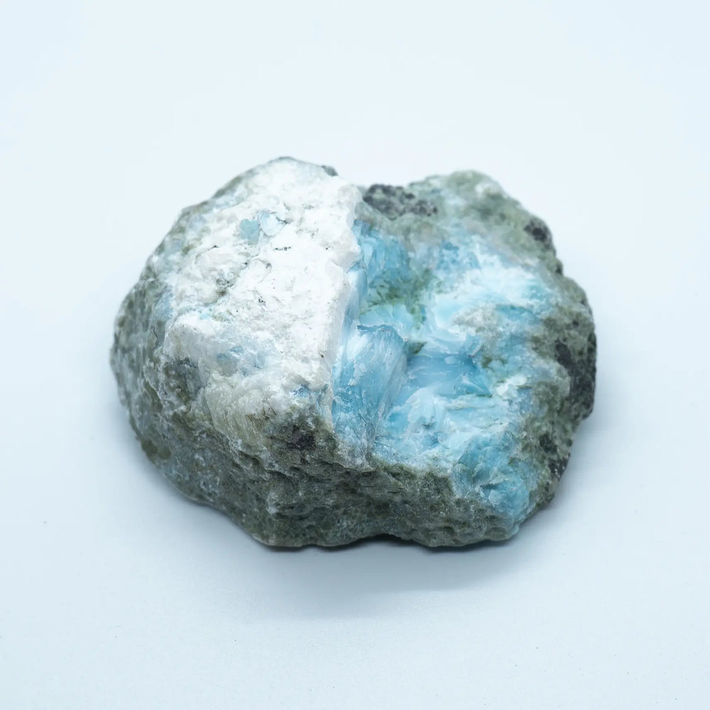 Bloc de roche vue sur son coté verso, non polie, avec la présence de Larimar de couleur bleu. Le Larimar non poli à une couleur bleu pale et le polissage lui donne sa couleur bleu intense. Pierre naturelle idéale pour un collectionneur de minéraux.