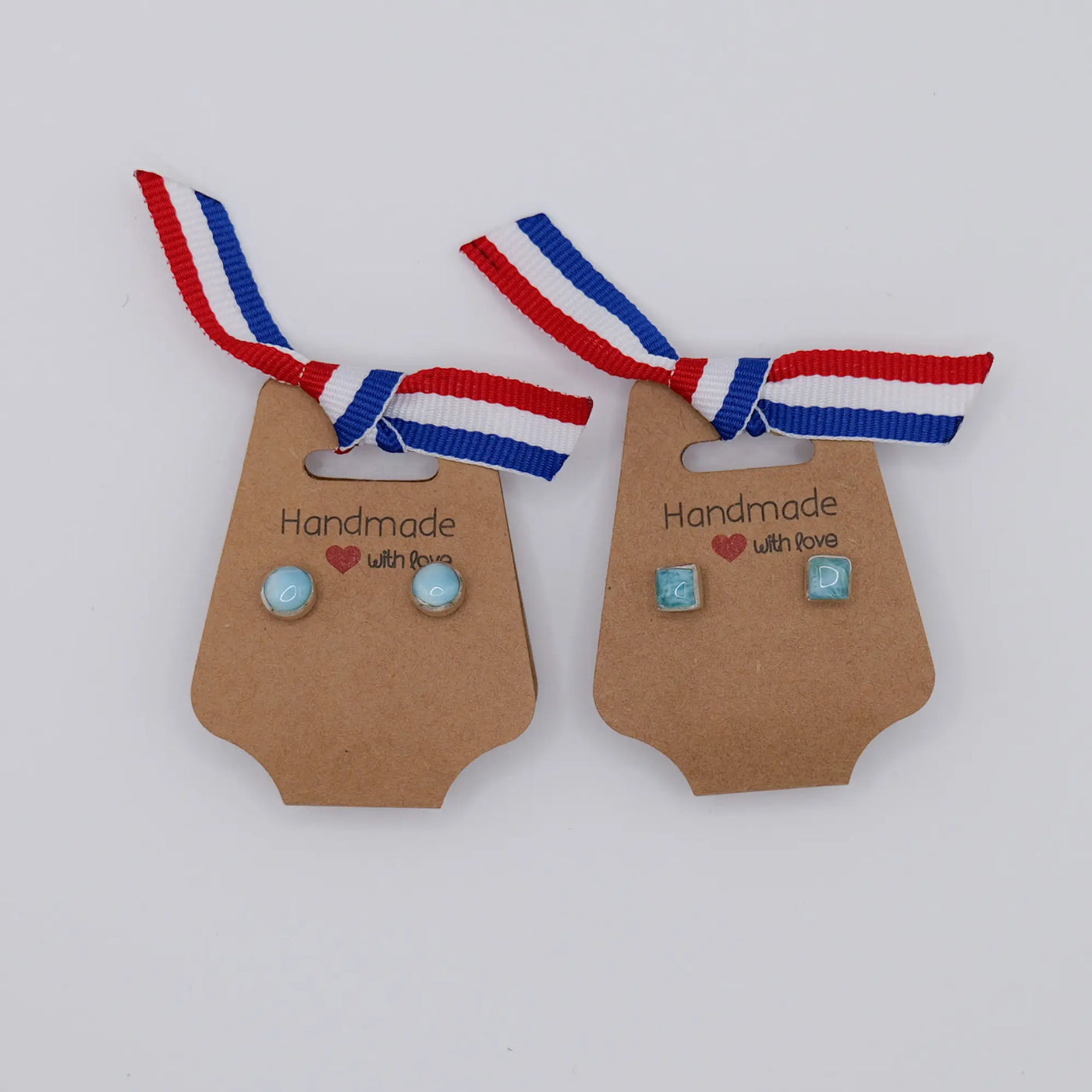 Une paire de boucles d'oreille ronde et une paire carré faite en Larimar de couleur bleue et sertie avec de l'argent 925.