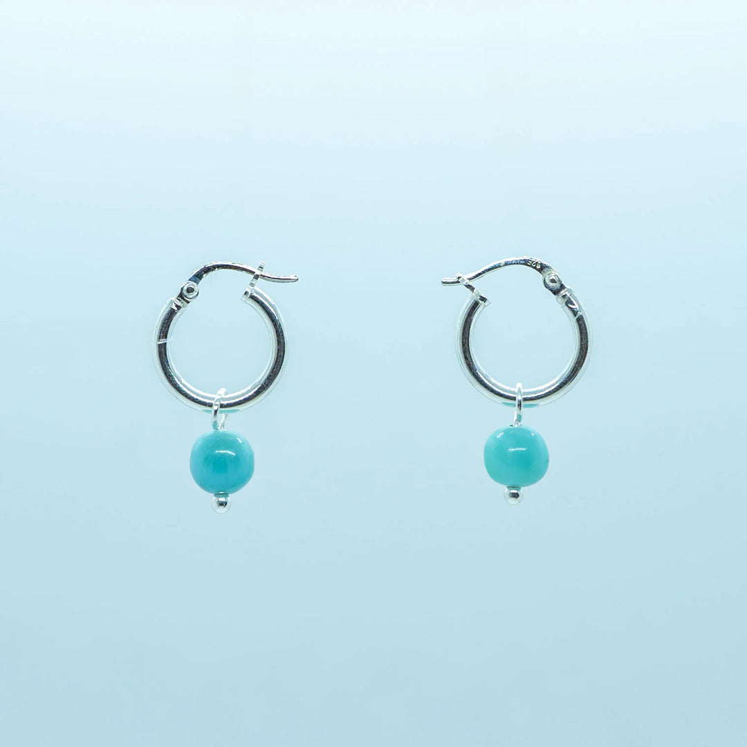 Photo d'une paire de boucles d'oreilles en argent 925, en formme de petite créoles, avec une pierre de Larimar pendante