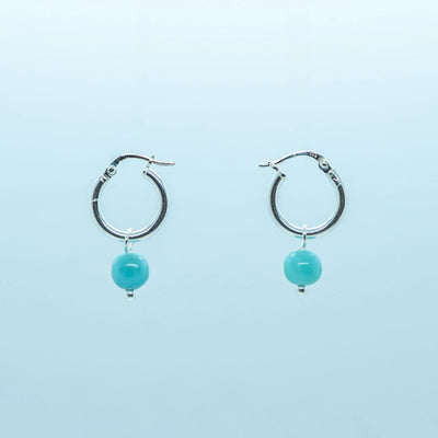 Photo d'une paire de boucles d'oreilles en argent 925, en formme de petite créoles, avec une pierre de Larimar pendante