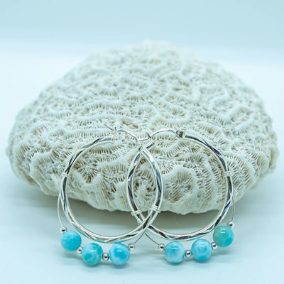 Boucles d'oreilles créoles en argent 925 texturées. Trois perles de larimar avec des petites perles intercalaires en argent montés sur un fil argent attachés à chaque boucle d'oreille.