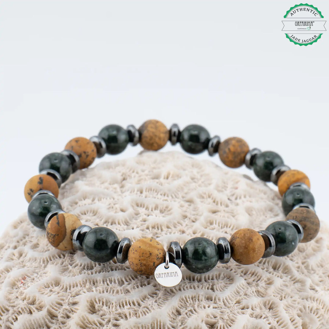 Bracelet en fil élastique avec sa breloque Orparima avec une alternance de perles de 8mm en Jade Jaguar Maya du Guatemala et en Jaspe paysage. Bracelet fabriqué artisanalement en République Dominicaine.