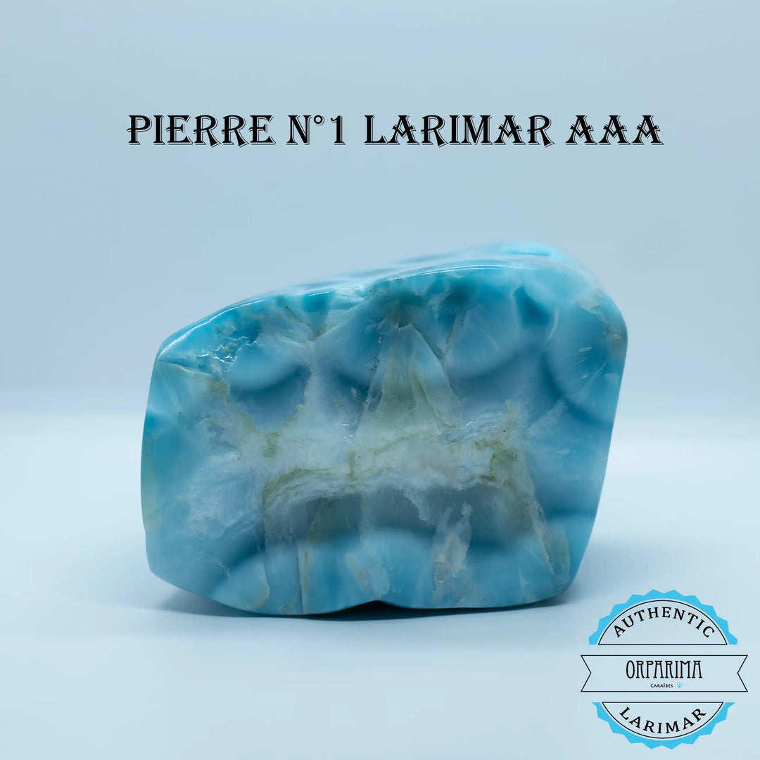 Larimar de République Dominicaine avec plusieurs teintes de bleu, posé sur fond blanc. Pierre naturelle façonnée artisanalement pour retirer la présences d&
