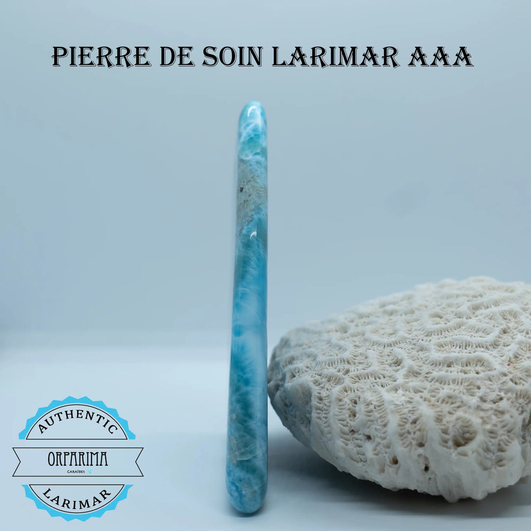 Pierre de soin pour énergéticien ou magnétiseur vue de côté et posée contre un coquillage, sur fond blanc. Pierre plate d&