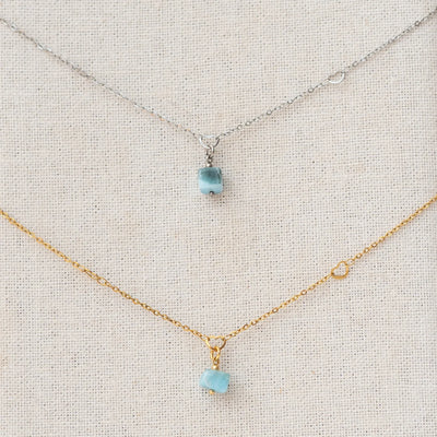 photo macro de deux sautoirs en acier inoxydable chirurgicale avec leur pendentif en pierre naturelle de Larimar. Bijou fait à la main unique au monde.