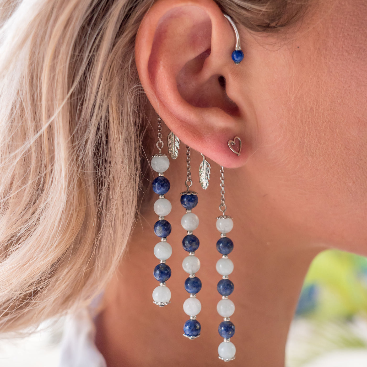 Photo d'une femme blonde vue de prés portant un tour d'oreille orparima et un boucle d'oreille en forme de coeur