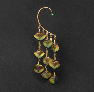 Orparima Tour d'oreille modèle "Le Paon" de la Collection Plumes, sur fond noir. Ce tour d'oreille est orné d'une Jade d'Afrique sur le devant.