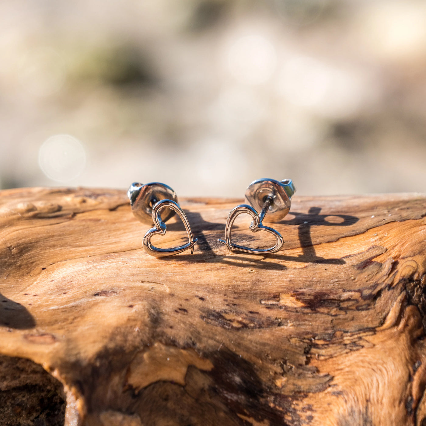 Boucles d'oreilles modèle "Coeur" de chez Orparimasur un morceau de bois flotté. Bijoux dorés dans un bain de Palladium.