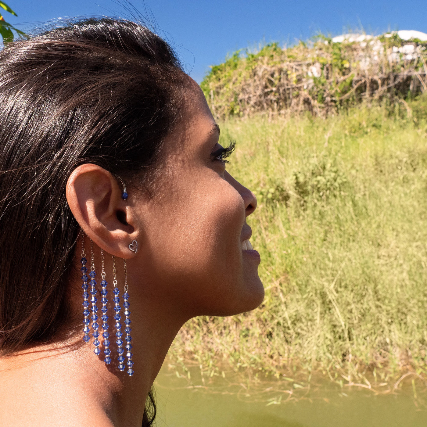 Orparima tour d'oreille "Blue Diamond" en vue de profil; collection Swarovski. Maritza porte aussi les boucles d'oreilles Coeur. Bijoux dorés au Palladium